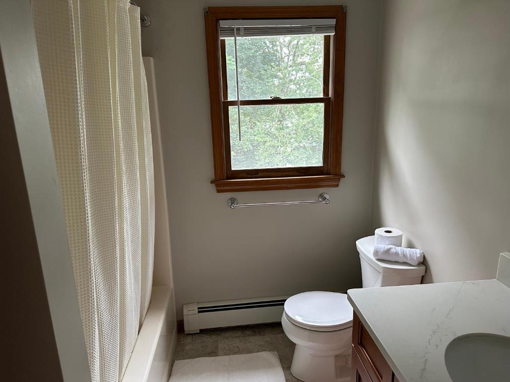 baño con aseo y ventana en Room in Single Family House - Suburban Neighborhood in Boston, en Boston