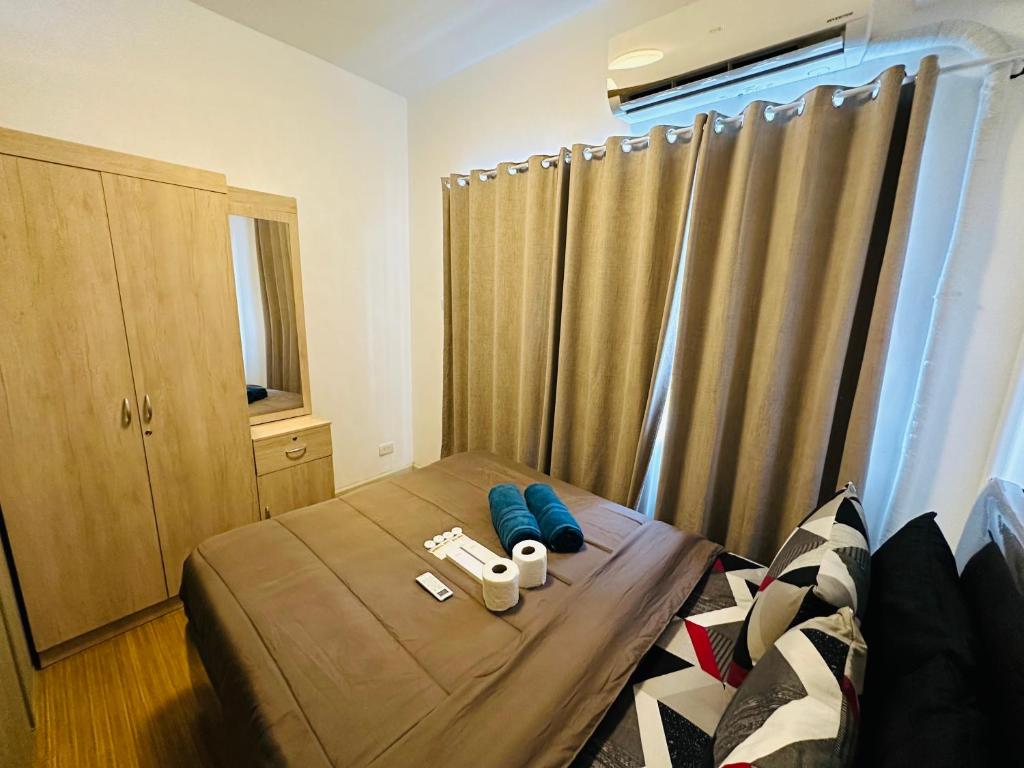 een slaapkamer met een bed en een raam met gordijnen bij Taguig 1 bedroom with balcony Plus Netflix Near Bgc and Airport in Manilla