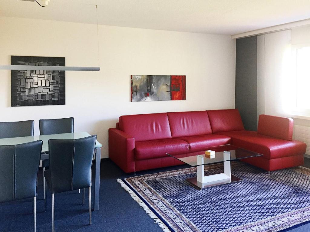 ディゼンティスにあるDisentiserhof C502のリビングルーム(赤いソファ、テーブル付)