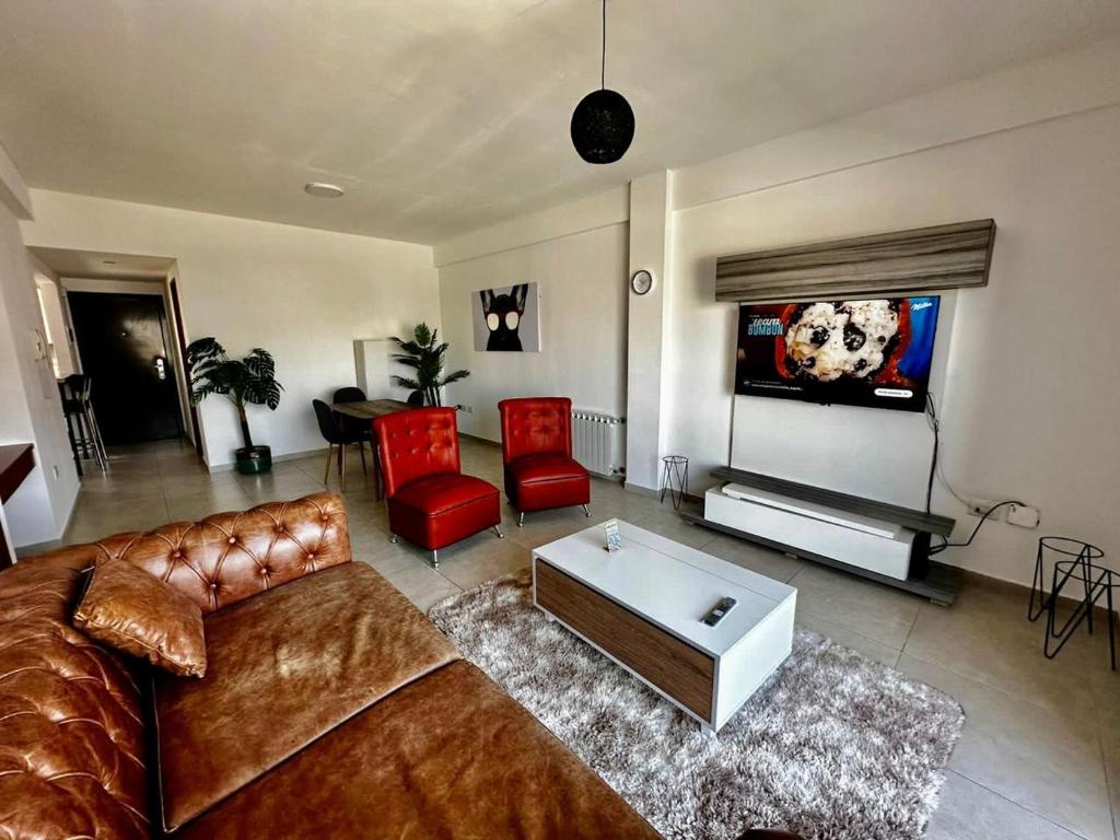 sala de estar con sofá y TV en Center Suites, 3 ambientes con cochera opcional en La Plata