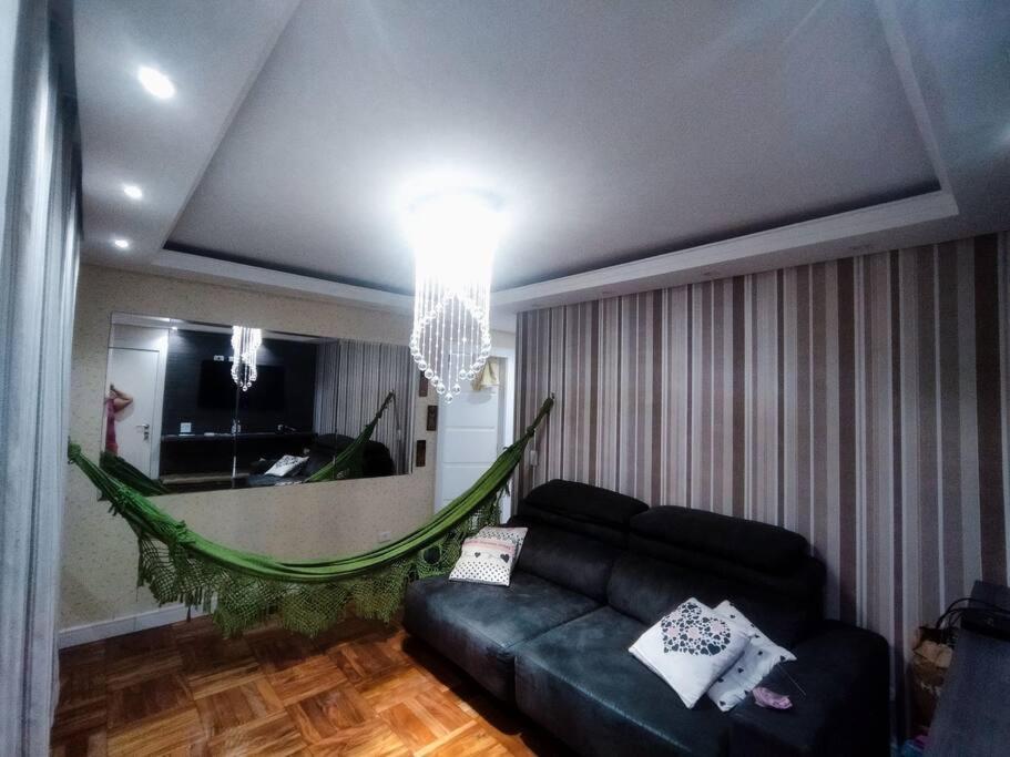 sala de estar con sofá y espejo en Super aconchegante Bem localizado, prox Ibirapuera, en São Paulo