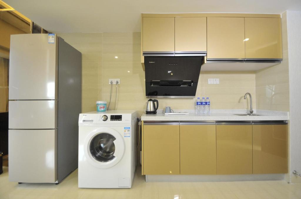 a kitchen with a washing machine and a refrigerator at WAIFIDEN Duplex Hotel Apartment Zhongyong Jinyu Branch-Free shuttle bus during the Canton Fair in Guangzhou