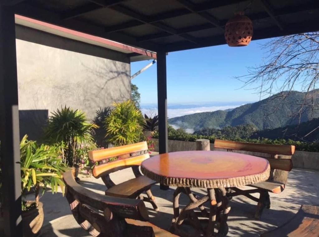 a table and chairs on a patio with a view at ม่านฟ้าฮิลล์ ภูชี้ฟ้า 