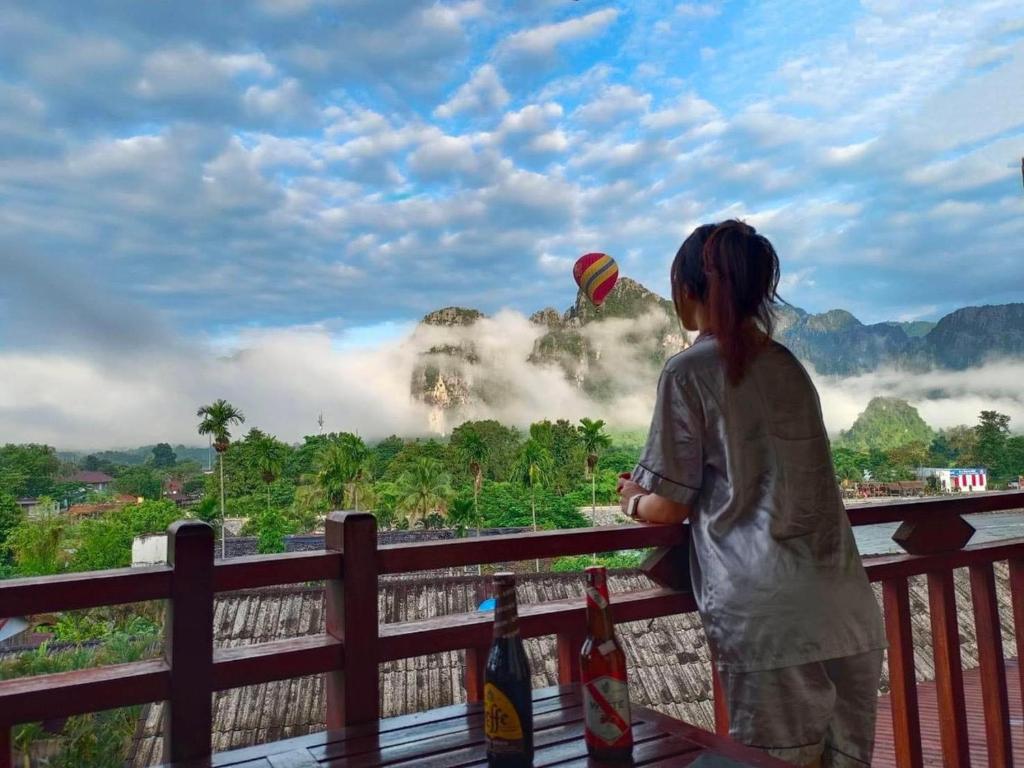 een jong meisje dat vliegert over een hek bij Hana Riverside Hotel in Vang Vieng