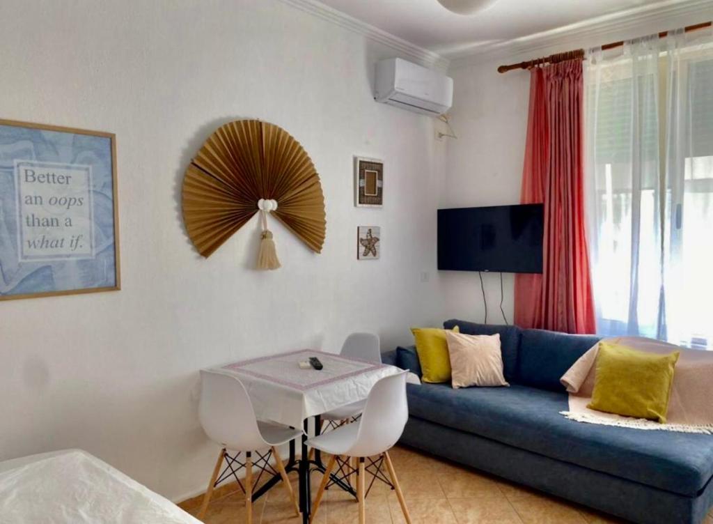 a living room with a blue couch and a table at Livi beachfront Apartment in Durrës