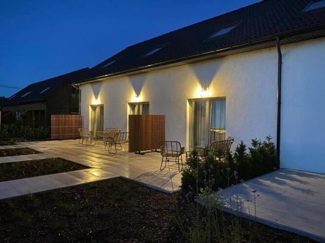 a house with chairs and a patio at night at Comfortable holiday home for 5 people, Grzybowo in Grzybowo