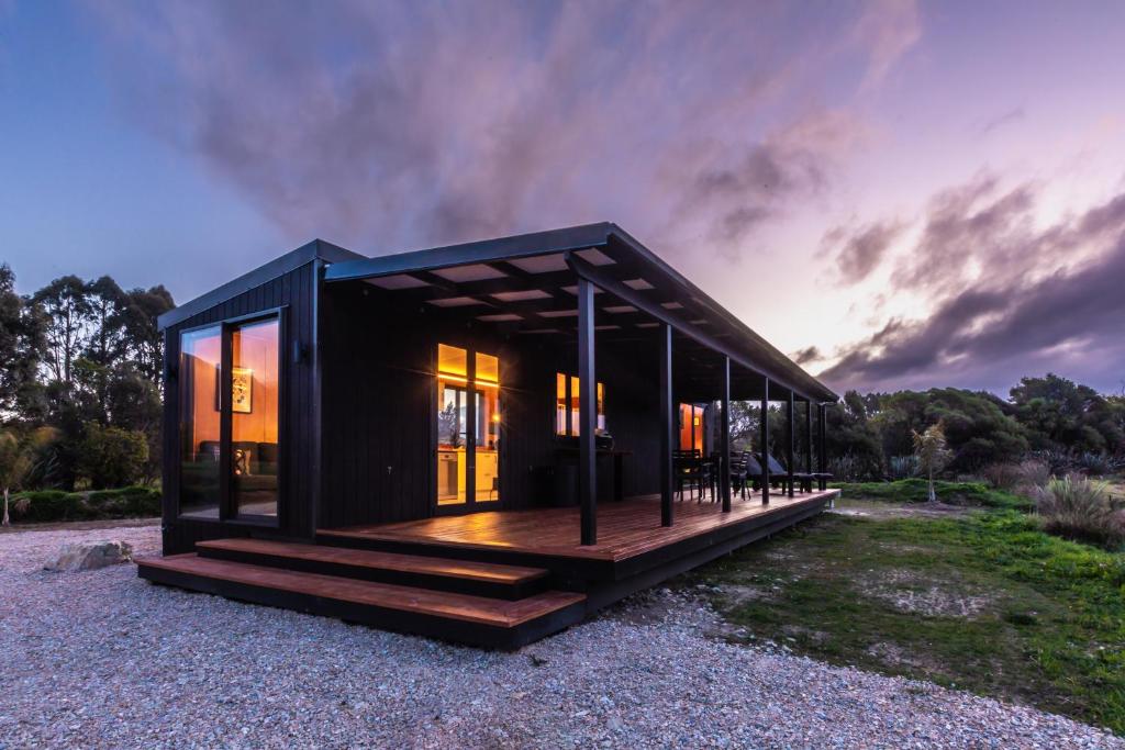 a black tiny house with a wooden deck at Relaxing Getaway in Pohara in Pohara