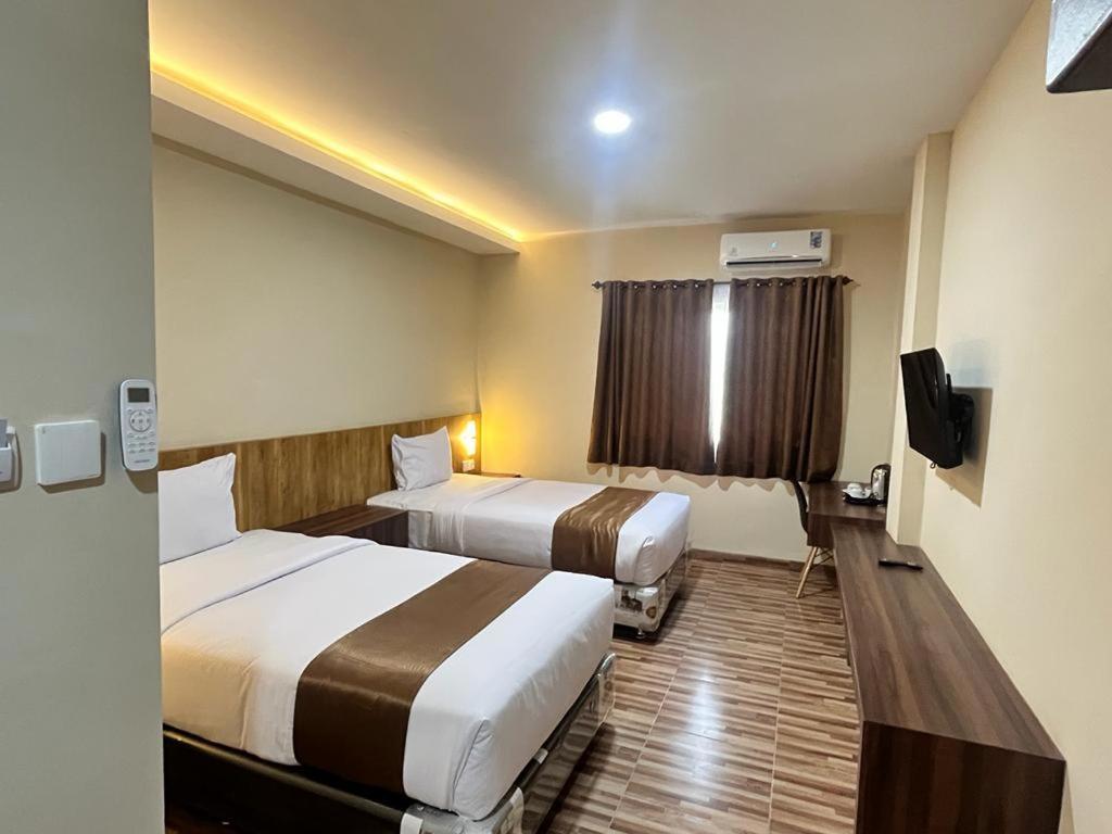 Postel nebo postele na pokoji v ubytování T HOTEL KUALANAMU
