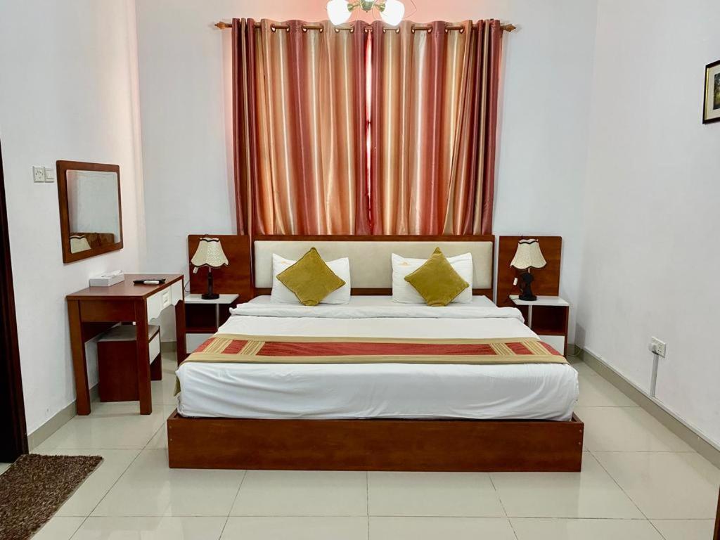 a bedroom with a large bed and a window at Wanasa Inn Apartments in Mawāliḩ