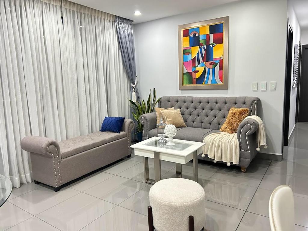 a living room with a couch and a table at Elegante y espacioso condominio in San Pedro Sula