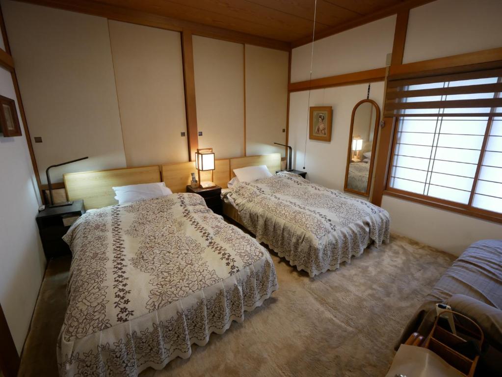 1 Schlafzimmer mit 2 Betten und einem Fenster in der Unterkunft Natural Mind Tour guest house - Vacation STAY 23292v in Sado