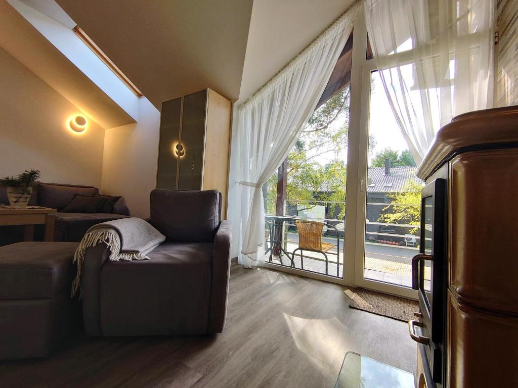 uma sala de estar com um sofá e uma grande janela em PUŠIES namai em Nida