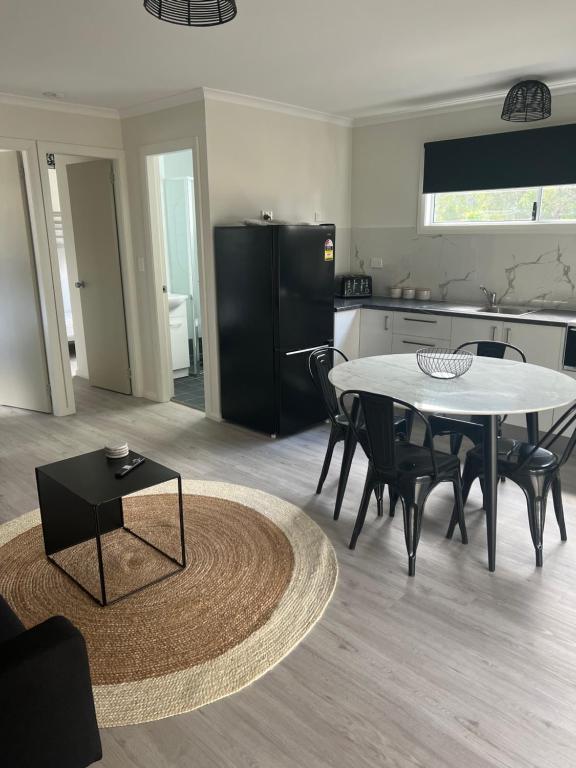 a kitchen and dining room with a table and chairs at Batemans Bay North Bush Cottages in Benandarah