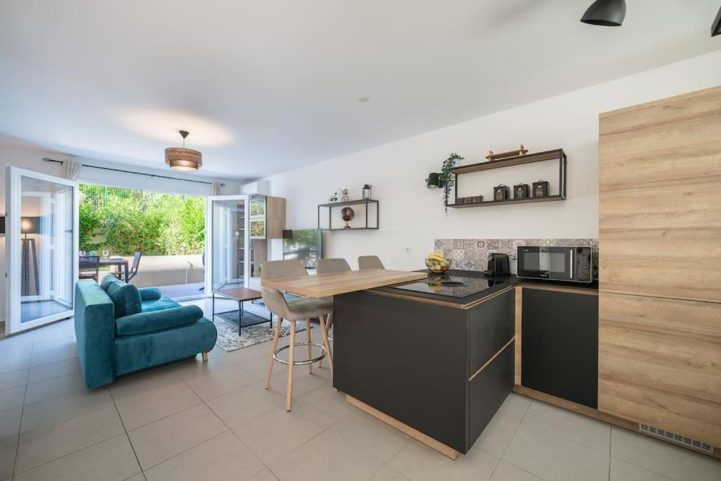 a kitchen and living room with a table and a blue couch at Villa Eden - Maison de ville au coeur de Menton, plage à 7 minutes in Menton