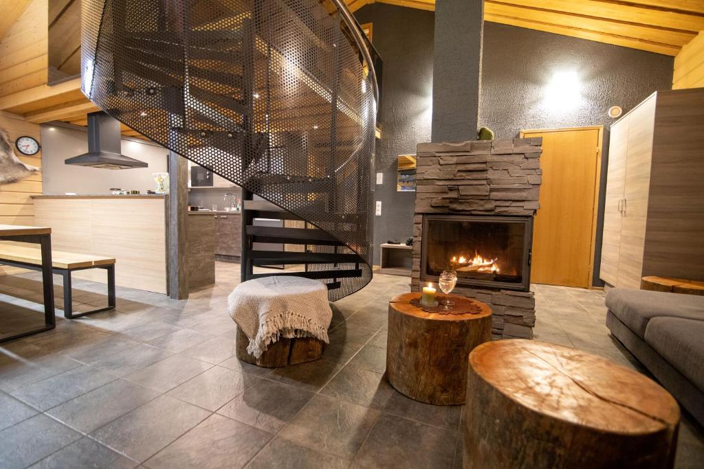 sala de estar con escalera y chimenea en Tunturipöllö 1, en Ruka