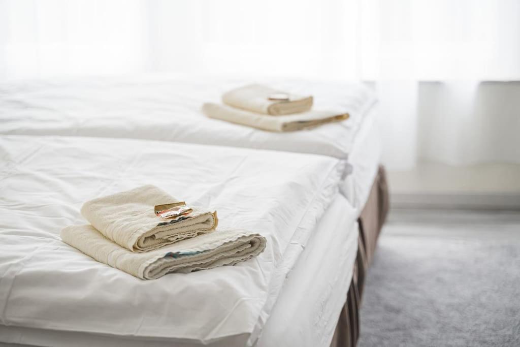 2 asciugamani e asciugamani sono seduti su un letto di BH03 Arbeiter Unterkunft für 4 Personen - 3 Schlafzimmer mit Küche a Neuhausen auf den Fildern