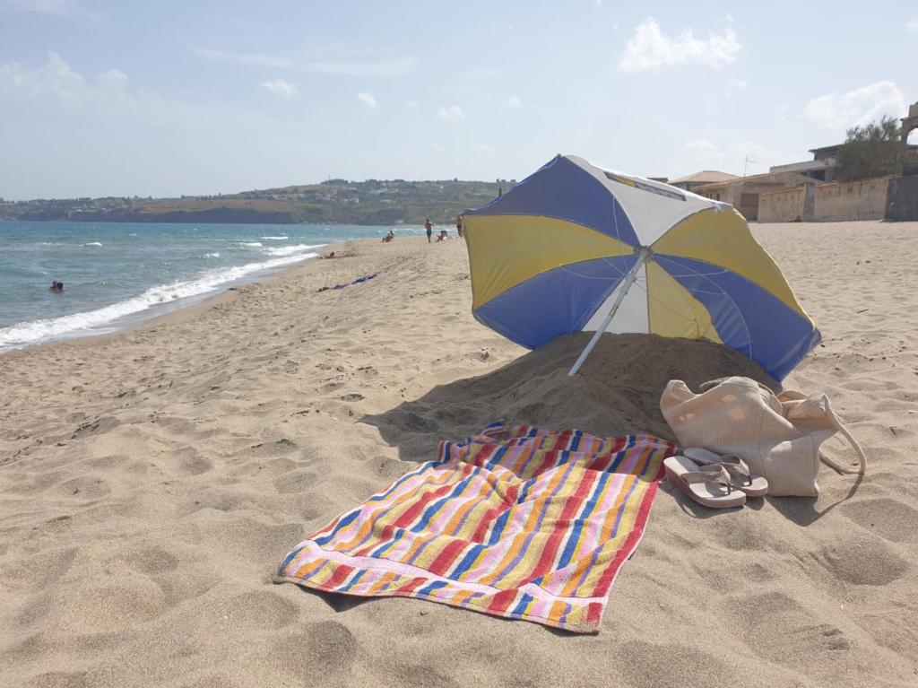 a towel and an umbrella on a beach at Casa Melina e enzo in Agnone Bagni