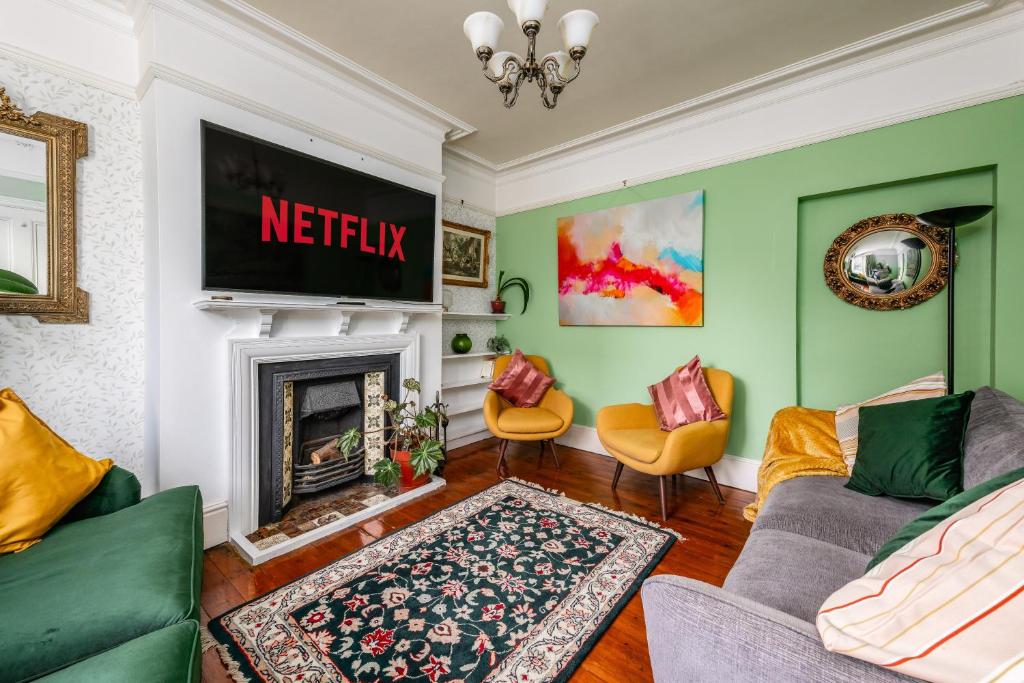 a living room with green walls and a fireplace at 5 bed Central Cambridge House in Cambridge
