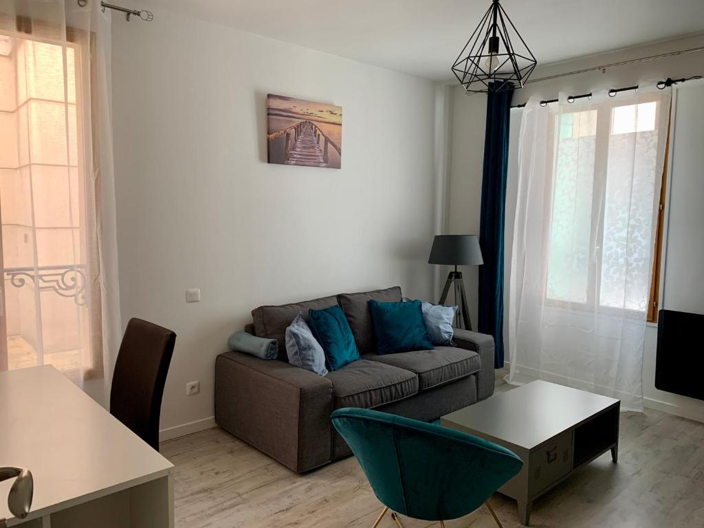 a living room with a couch and a table at Le passage de Hugues - 3 chambres - hyper centre in Troyes