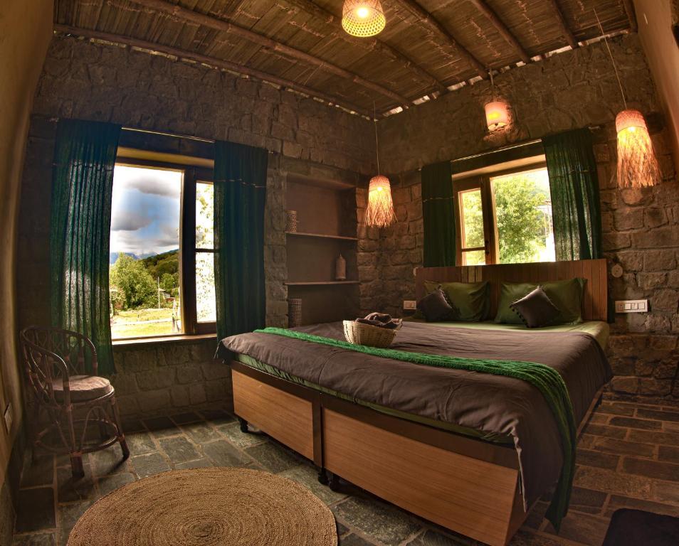 una camera con un letto in una stanza con finestre di Hobbit House Bir a Bīr