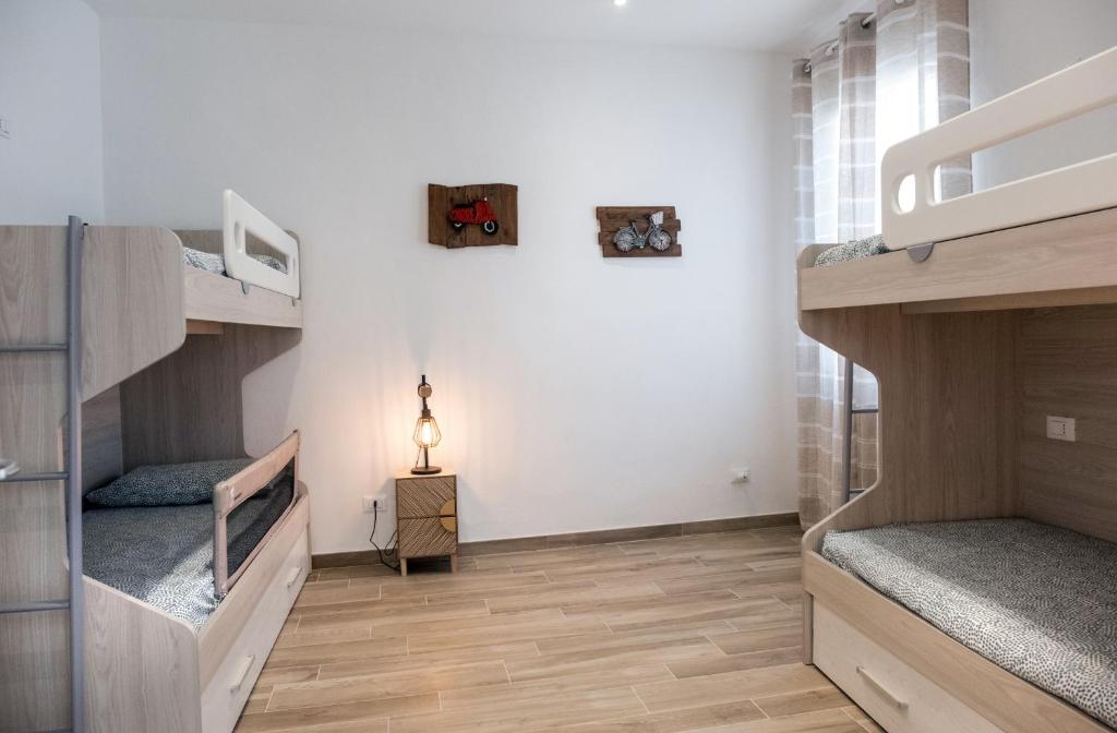 a room with two bunk beds and a lamp at 70mt dal mare in Viareggio
