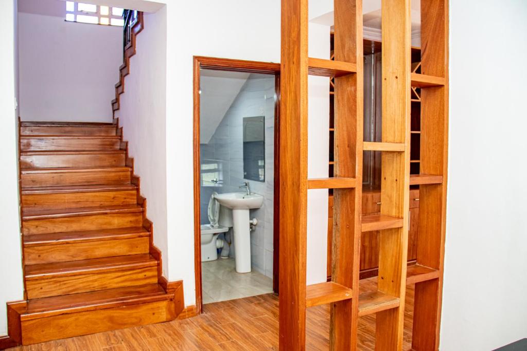 a stairway leading to a bathroom with a wooden door at Kathy's Place in Runda in Nairobi