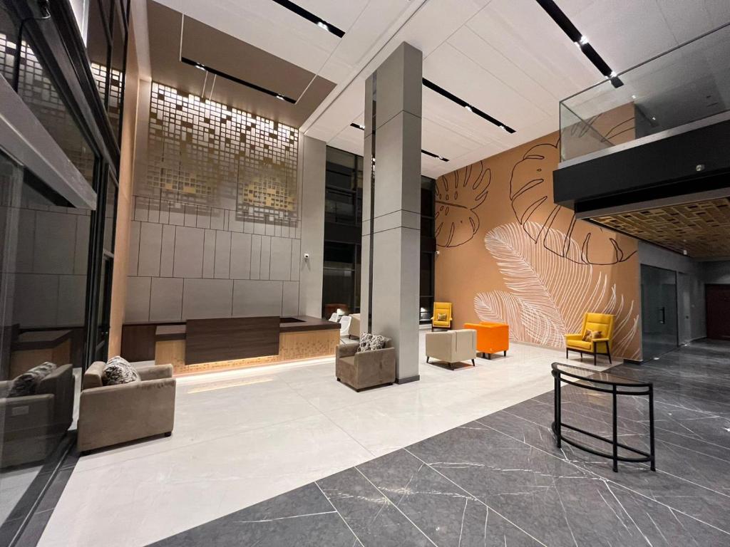 a lobby of a building with a wall with a mural at PRESIDENCY AIRPORT HOTEL in Cochin