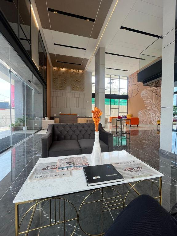 a living room with a table and a couch at PRESIDENCY AIRPORT HOTEL in Cochin