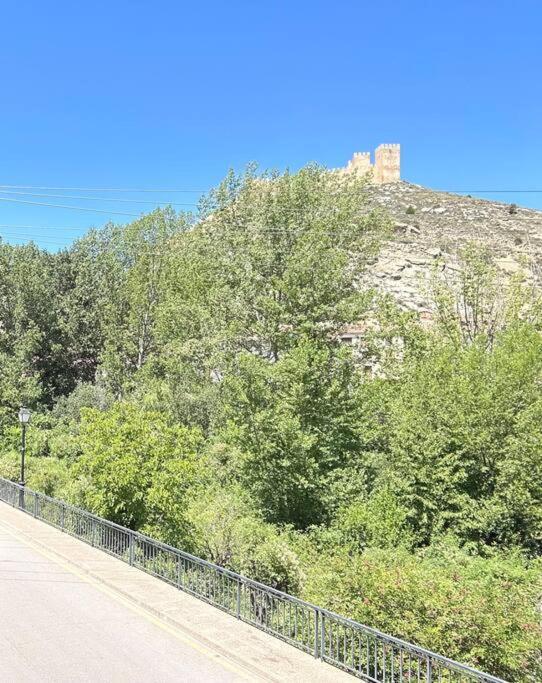 a building on top of a hill with trees at Apartamento Casa Florentina in Albarracín