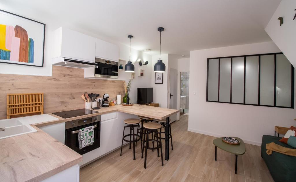 cocina y sala de estar con mesa y sillas en T2 cosy et climatisé au cœur de la ville - La Golondrina, en Martigues