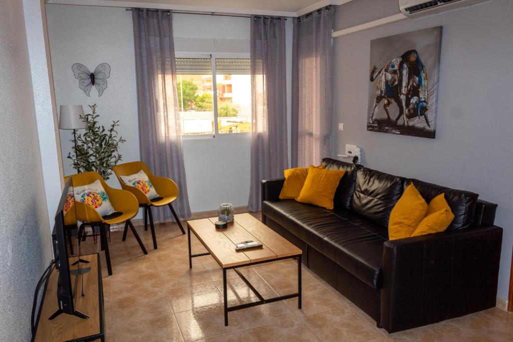 - un salon avec un canapé en cuir noir et des oreillers jaunes dans l'établissement City Comfort, Your Torrevieja Retreat, à Torrevieja