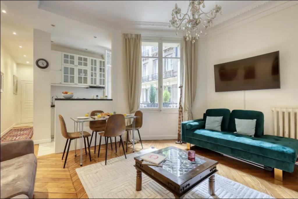 a living room with a couch and a table at Typical Chic Parisian Flat-Near les Champs-Élysées in Paris