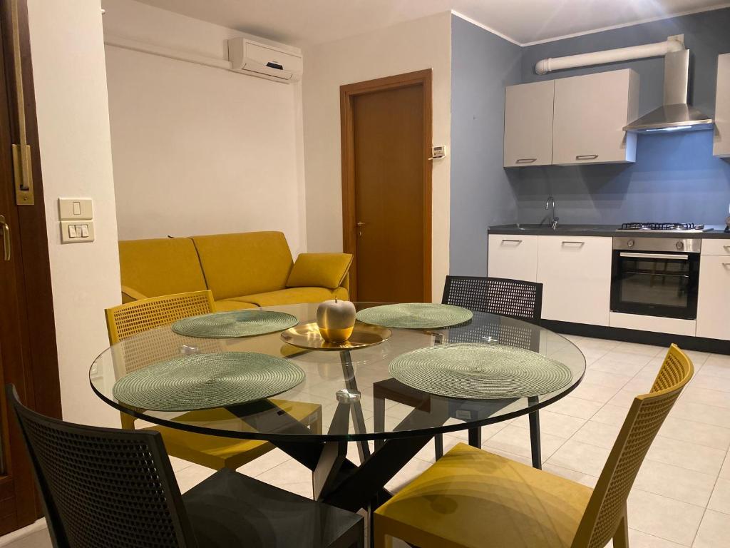 a living room with a table and chairs and a kitchen at Il Principio - zona Fiera e Policlinico in Pordenone