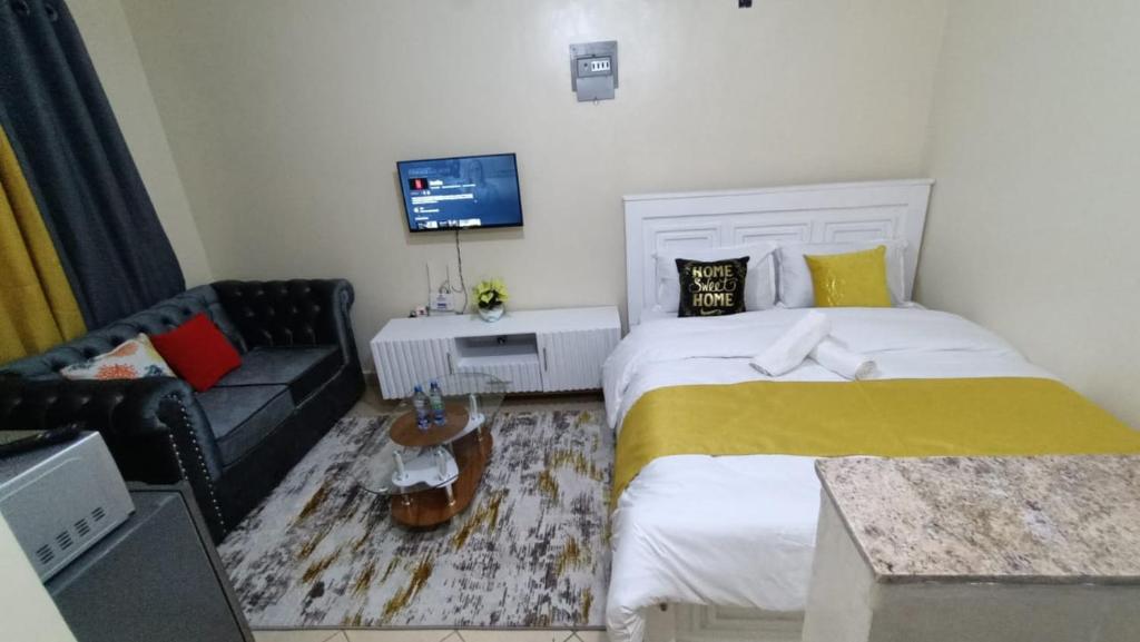 ein kleines Schlafzimmer mit einem Bett und einem Sofa in der Unterkunft Amir in Nairobi