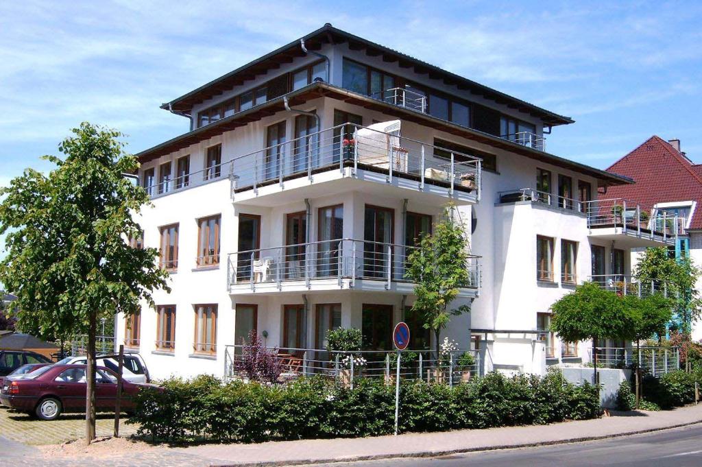 ein weißes Gebäude mit Balkon auf der Seite in der Unterkunft Haus am Strand Ferienwohnung Nr 03 in Häven