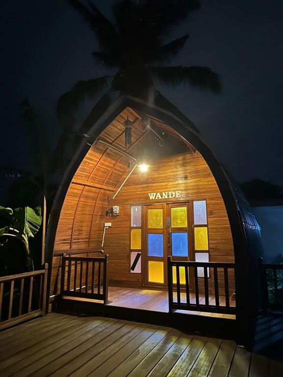 un edificio de guardias con terraza de madera por la noche en LBA chalet, en Balik Pulau