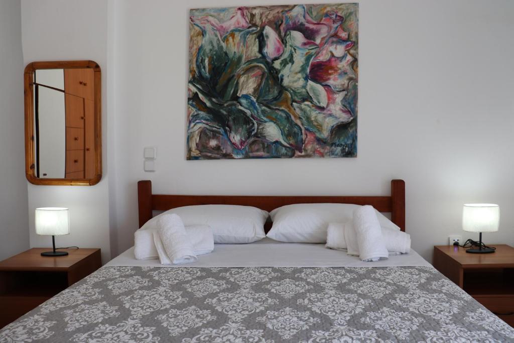 a bedroom with a bed with a painting on the wall at City Apartment Ierapetra in Ierápetra