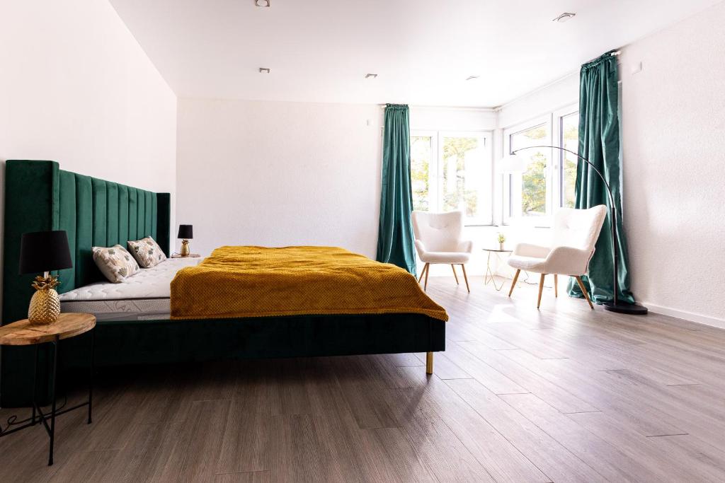a bedroom with a large bed with green curtains at Design Apartment zentral für 6 in Andernach: Ausblick, WiFi, Küche in Andernach