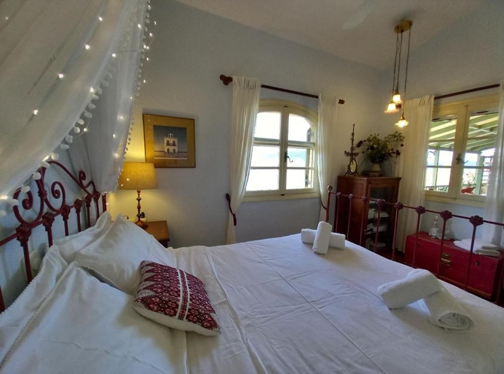 sypialnia z dużym białym łóżkiem z 2 poduszkami w obiekcie Aphrodite's Coast Retreat House! w mieście Galaxidi