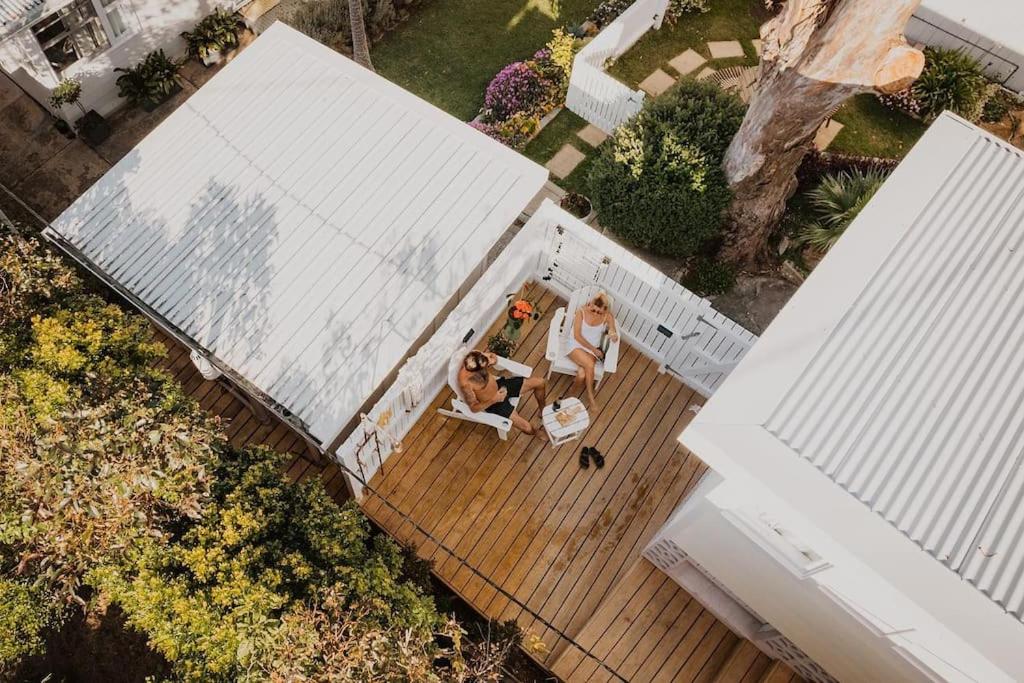 dos mujeres sentadas en una terraza en una casa en George @ Ethel & Odes, en Bundeena