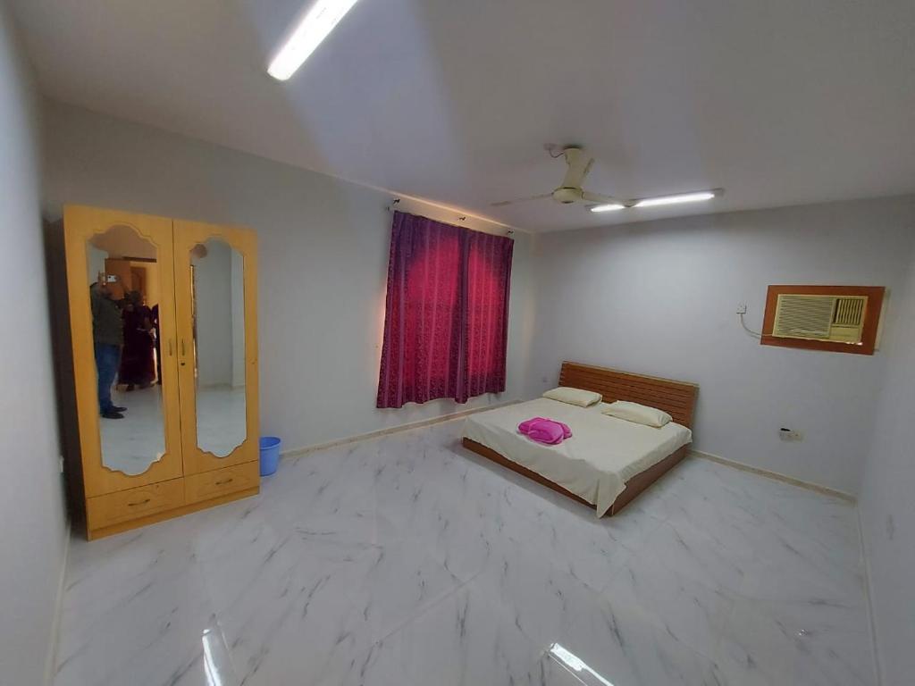 una stanza con un letto e uno specchio di Manam a Mascate
