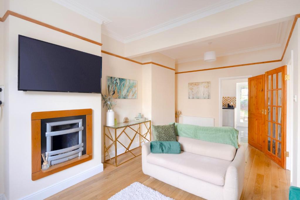 sala de estar con sofá blanco y TV en Stylish House in Wimbledon en Londres
