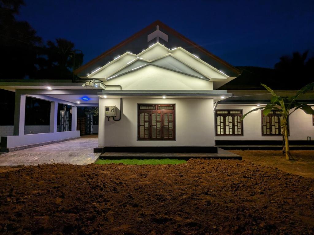 uma casa branca à noite com luzes em KATHIR Guest House em Jaffna