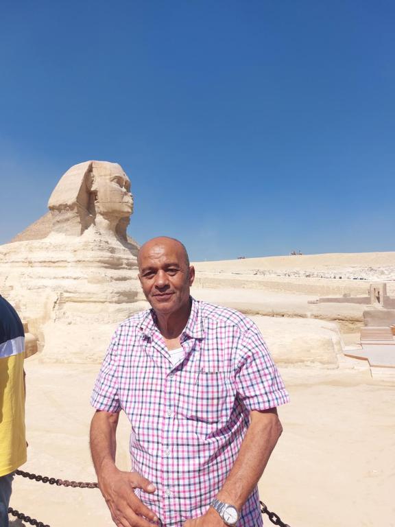 un hombre parado frente a una estatua en el desierto en Renting a private car with private driver, en El Cairo