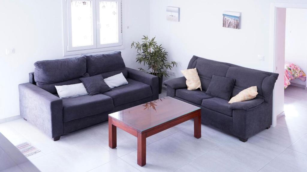 Sala de estar con 2 sofás y mesa de centro en APARTAMENTO TURÍSTICO CASA MIGUEL, en Matalascañas