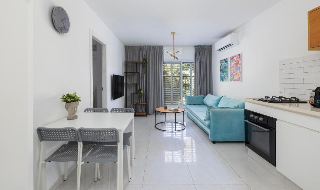 a kitchen and living room with a blue couch at Central and beautiful - MORE apartments in Beer Sheva