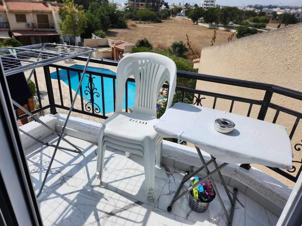 two white chairs and a table on a balcony at Jasmin Gardens in Paphos City