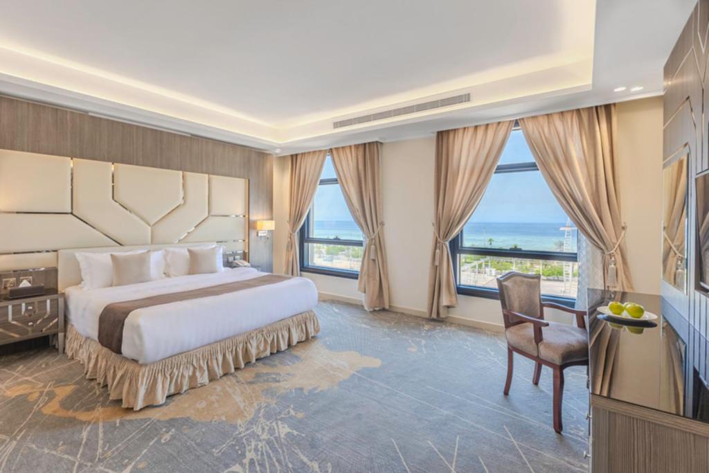 a bedroom with a large bed with a large window at Guest House Hotel Apartments in Yanbu