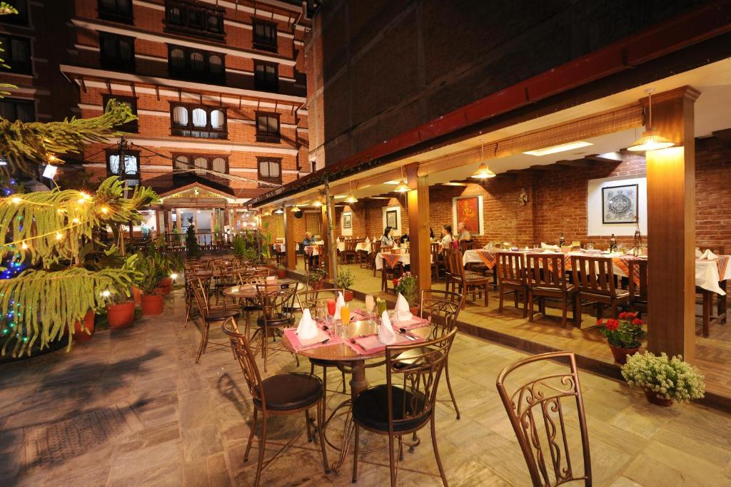 a restaurant with tables and chairs in a building at Apsara Boutique Hotel in Kathmandu