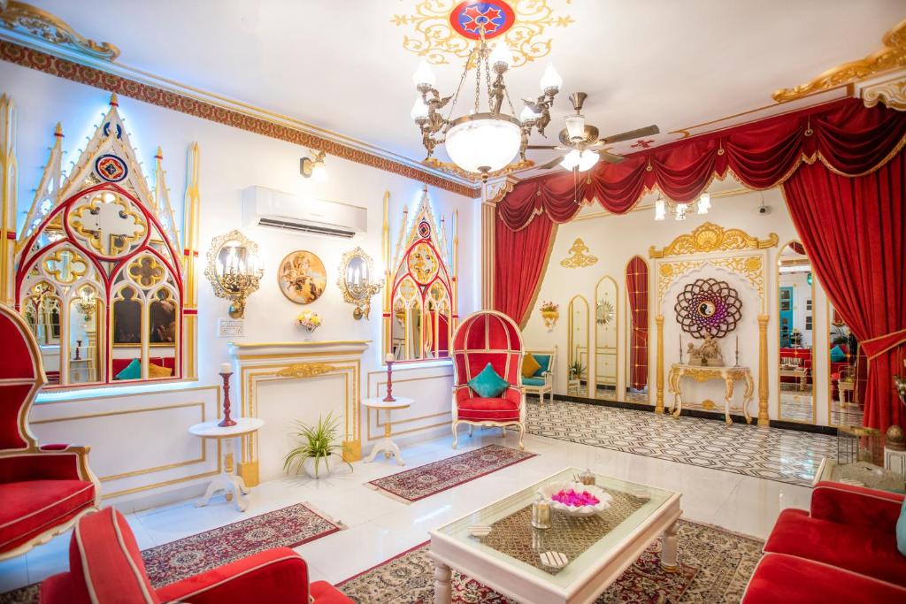 una sala de estar con sillas rojas y una lámpara de araña. en The Royal Hermitage - Best Luxury Boutique Hotel Jaipur en Jaipur